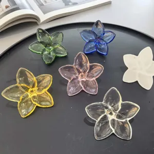 Macro detail of colorful crystal glass flower ornaments on a black decorative tray.
