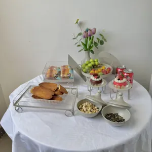 Variedad de bandejas para aperitivos y soportes para postres en mesa blanca limpia.