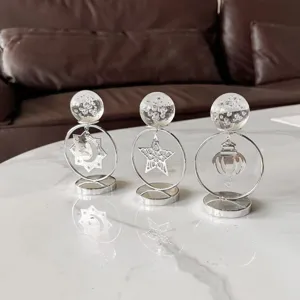 Detalle de adornos de bola de cristal bañados en plata con motivos de estrella y luna.