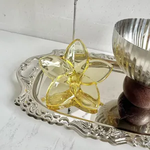 Detailed macro view of a luxury yellow crystal glass flower ornament displayed on a silver tray