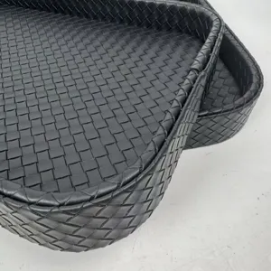 Macro close-up detail of black woven leather texture on a rectangular home decor tray