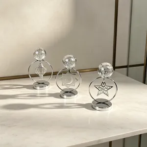 Detalle de tres adornos de hierro plateado con bolas de cristal y motivos huecos