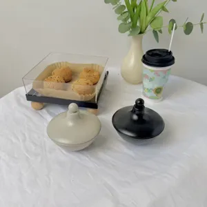 Bandeja de postres de estilo europeo con tapa acrílica y cuencos con tapa en la mesa.