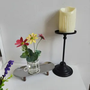 Close-up of creative glass flower vase with iron holder on a silver metal tray decor