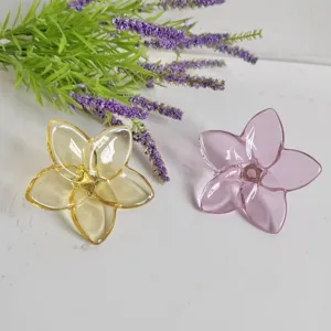Detailed macro view of elegant yellow and pink crystal glass flower ornaments on white