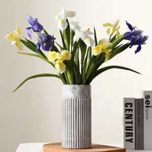 Detailed view of hand-feel PU iris artificial flowers in a marble textured ribbed vase