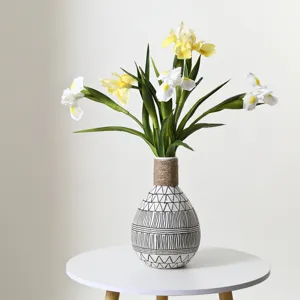 Realistic yellow and white PU iris artificial flowers in a patterned ceramic vase