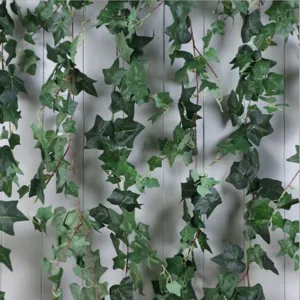 Detailed macro view of 2m artificial green ivy vine hanging on a white wooden wall.