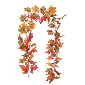 Détail d'une guirlande de feuilles d'érable artificielles aux couleurs d'automne rouge et orange.