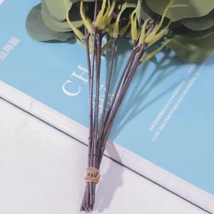 Close-up of artificial eucalyptus stems bundled together on a blue background