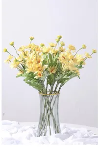 Elegant bouquet of yellow artificial small daisies displayed in a glass vase