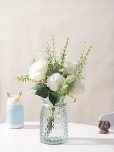 Elegante bouquet di rose bianche artificiali con verde in vaso di vetro per la casa.