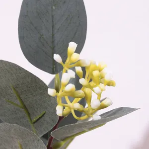 Close-up detail of artificial eucalyptus leaves and small white berries for decor