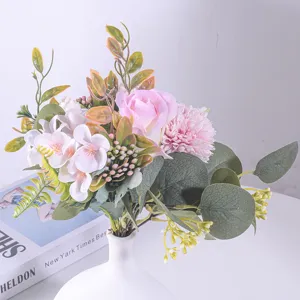 Primo piano di un bouquet di rose artificiali rosa con eucalipto in vaso