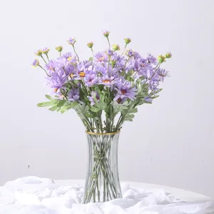 Elegant bouquet of purple artificial daisies in a glass vase for home and wedding decor