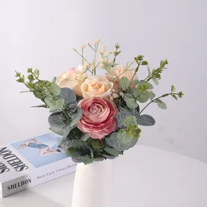 Elegante bouquet di ranuncoli di seta e gipsofila artificiale in un vaso di ceramica bianco