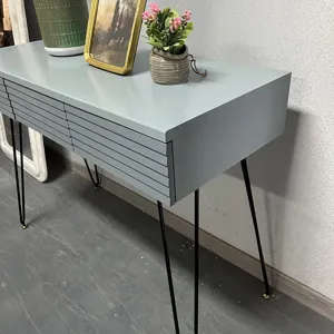 Side view of a grey modern dressing table featuring fluted drawer fronts and black hairpin legs