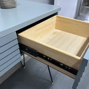 Detailed macro view of a solid wood drawer interior with black metal slide rails