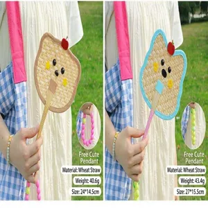 Detailed view of handmade woven straw fans with cute animal designs and beads.