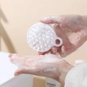 Ergonomic white silicone scalp massage brush with soft bristles and rich soapy foam