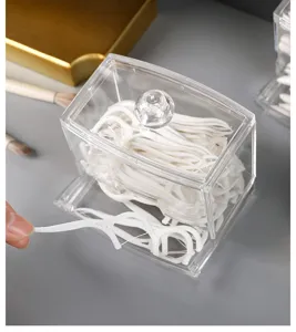 Close-up of a clear acrylic organizer box filled with white dental floss picks.