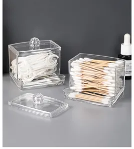 Detailed macro view of transparent acrylic storage organizers for cotton swabs and floss