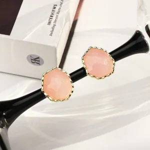 Detailed view of pink glitter hexagonal stud earrings featuring an elegant gold frame