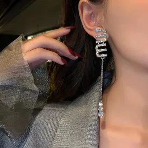 Detailed close-up showing a model wearing sparkling rhinestone Miu letter tassel earrings
