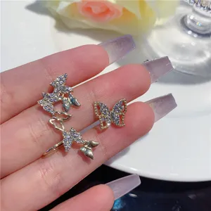 Detailed close-up of luxury gold butterfly ear cuffs with shimmering micro-pave rhinestones