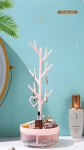 Elegant pink rotating tree branch rack for jewelry and cosmetic organization on desk