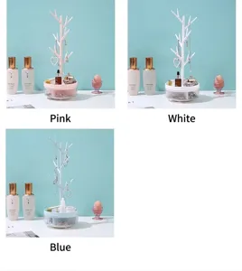 Multi-color branch jewelry rack organizer for earrings and necklaces in pink, white, and blue.