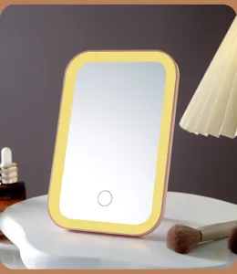 Close-up of portable LED makeup mirror with warm yellow light ring on white vanity stand