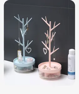 Gros plan sur des porte-bijoux en forme d'arbre rose et bleu avec bases rotatives