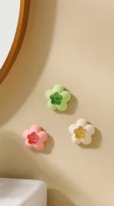 Detailed view of flower-shaped bathroom air fresheners in pink, green, and cream.