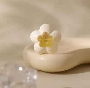 Close-up shot of a minimalist cream flower-shaped air freshener with a yellow gel core.