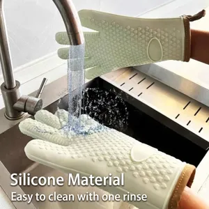 Gants de cuisine en silicone vert clair résistants à la chaleur rincés sous le robinet