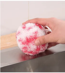 Vue rapprochée de la boule de nettoyage nano rose et blanc tenue à la main pour l'échelle