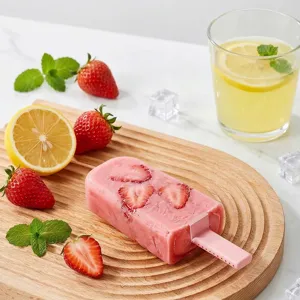 Homemade strawberry popsicle in a silicone mold with fresh fruits on a wooden tray