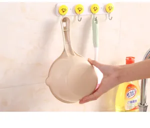 Beiger dicker Kunststoff-Wasserschöpfer mit langem Griff in einer funktionellen Küche