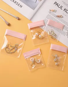 Small transparent EVA jewelry storage bags with pink seals protecting earrings from oxidation