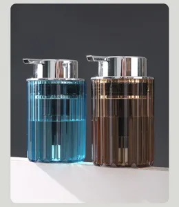 Two elegant ribbed glass-style foam dispensers in blue and amber with chrome pumps
