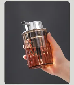 Close-up of amber ribbed lotion dispenser bottle with silver pump head held in hand