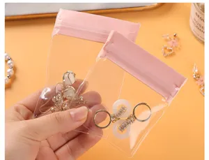 Close-up of pink EVA anti-oxidation jewelry storage bags with earrings held by hand