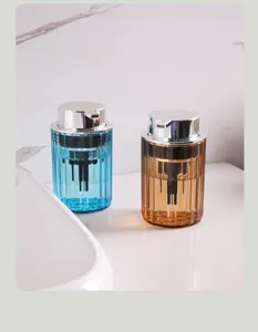 A pair of blue and amber ribbed refillable foam dispenser bottles on a white bathroom sink