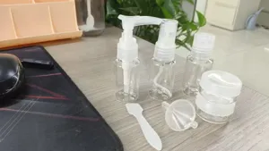 Detailed macro view of clear plastic travel toiletry bottle set with pump and spray.