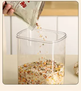 Close-up of a clear airtight container being filled with mixed grains for kitchen organization