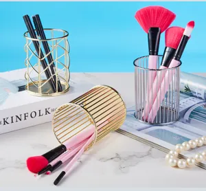 Elegant gold and silver metal makeup brush holders with Nordic minimalist design on a desk