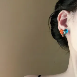 Detailed view of an orange and blue gradient heart stud earring being worn by a model