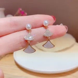 Close-up of elegant fan-shaped earrings with pearls and crystal inlay for a vintage look.