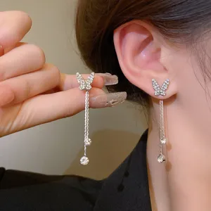 Elegant butterfly tassel earrings with sparkling rhinestones on an Asian model's ear